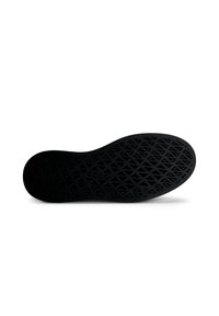 Semelle de chaussure noire présentant un motif géométrique texturé avec des formes triangulaires, fabriquée en matériau en caoutchouc durable.