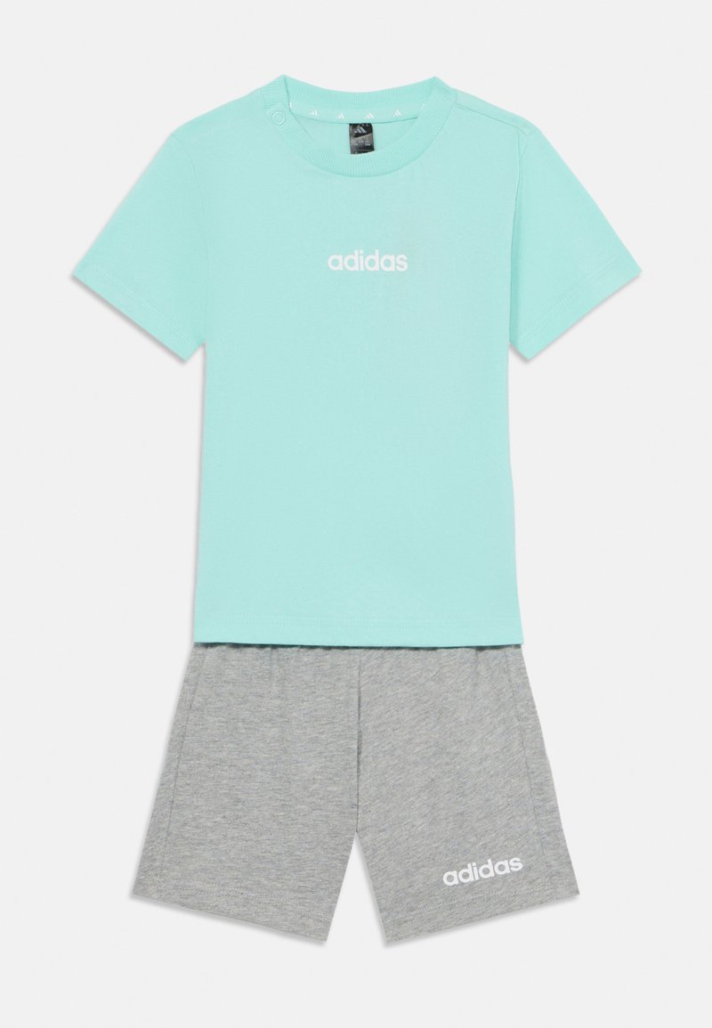 T-shirt verde menta de manga curta com detalhe de botões; combinado com calções cinza com um logo branco. Tecido em mistura de algodão, corte descontraído.