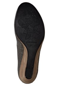 Svart gummiyttersula med ett blommönster, med en tan strukturerad kant. Inskription "Vagabond 37" nära hälen.