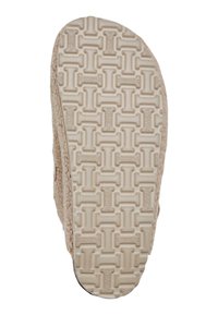 Semelle de chausson beige clair avec un motif texturé et un logo de marque en relief. Le matériau semble doux et durable, adapté à un usage intérieur.