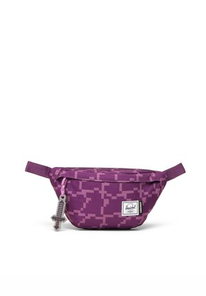Banane violette avec motif pixellisé, tirette de fermeture éclair en forme d'épée Minecraft, étiquette Herschel à l'avant, fond blanc. Aucun personnage présent.