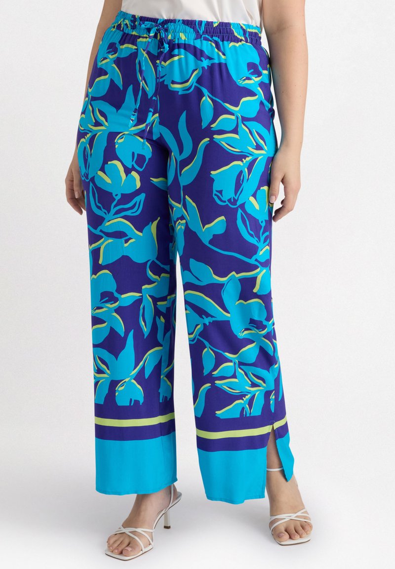 Pantalons légers et fluides en bleu et violet avec un motif floral. Avec une taille élastique et des fentes sur les côtés à l'ourlet.