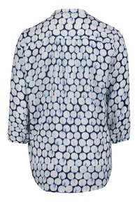 Blouse à manches longues avec fond bleu marine et motif de points circulaires blancs irréguliers, vue de dos avec un détail froncé sous le yoke.