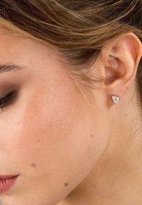 Päronformad diamantörhänge i roséguld, som visar en briljant slipning med en klar, reflekterande yta och släta kanter.