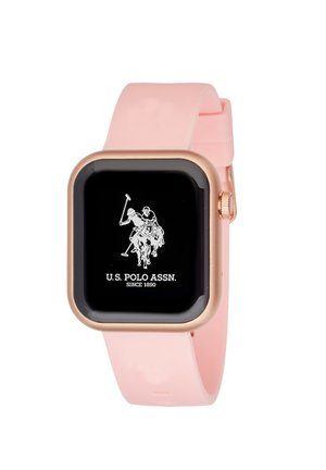 Montre connectée carrée avec un écran noir, un cadre en or rose et un bracelet en silicone rose. Présente le logo U.S. Polo Assn. en blanc.