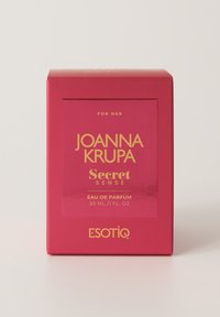 Różowe pudełko z złotym napisem "Joanna Krupa Secret Sense" oraz szczegółami "Eau de Parfum". Opakowanie ma kwadratowy kształt, jest błyszczące i oznaczone napisem "Dla Niej."