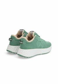 Baskets en daim vert avec une semelle extérieure blanche texturée, doublure beige douce et étiquette de marque noire sur le talon. Bout rond et design bas.