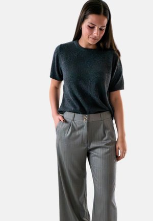 Donkergrijze top met korte mouwen en een gestructureerde afwerking, gecombineerd met lichtgrijze wijde broek met plooien en dubbele knoopsluiting.