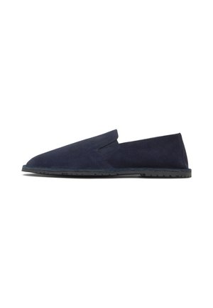 Zapato tipo mocasín azul marino con suela de goma plana y parte superior de ante, mostrado de lado sobre un fondo blanco.