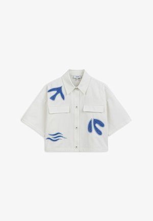 Short-sleeve cropped shirt in white fabric featuring blue embroidery of abstract shapes and waves, with two front pockets and button closure.