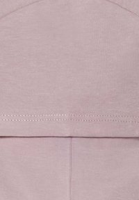 Šviesiai rožinė medvilnės medžiaga su švelniu paviršiumi. Pasižymi lygiomis siūlėmis ir paprastu, tiesiu kirpimo dizainu. Nėra matomų raštų ar akcentų.