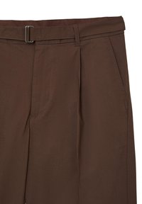 Nahaufnahme von braunen Hosen mit Seitentaschen und einem passenden Stoffgürtel mit rechteckiger Metallschnalle.