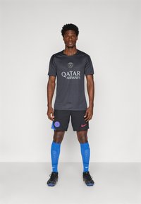 Black athletic jersey with “QATAR AIRWAYS” logo, black shorts with red Nike logo, blue socks, and black cleats. Smooth fabric, fitted design.