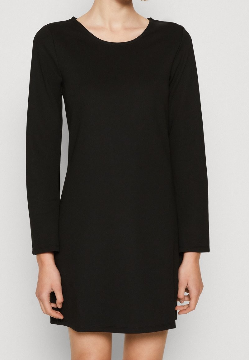 Svart långärmad klänning med rundad halsringning, tillverkad av ett slätt tyg, med rak passform och knälång fåll.