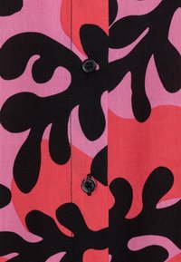 Camicia button-up con un audace motivo astratto in nero, rosa e corallo. Il tessuto sembra intrecciato con una consistenza liscia.