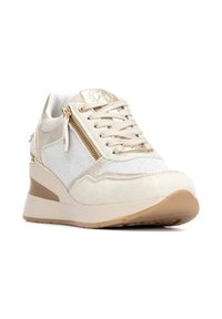 Zapatillas deportivas beige con detalles de ante, malla y acentos metálicos dorados. Cuentan con un tacón en cuña y un zipper lateral. Suela de goma texturizada.
