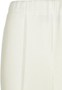 Pantalon en tissu blanc côtelé avec une ceinture large et des jambes droites. La surface présente un motif texturé.
