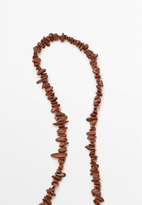 Bruine stenen kralenketting met ongelijkvormige kralen met een gladde textuur, gerangschikt in een doorlopende streng.