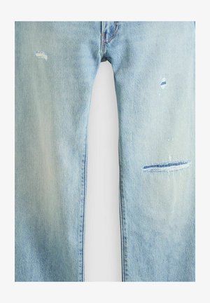 Light blue denim jeans with faded wash and three small distressed rips on the front thighs.