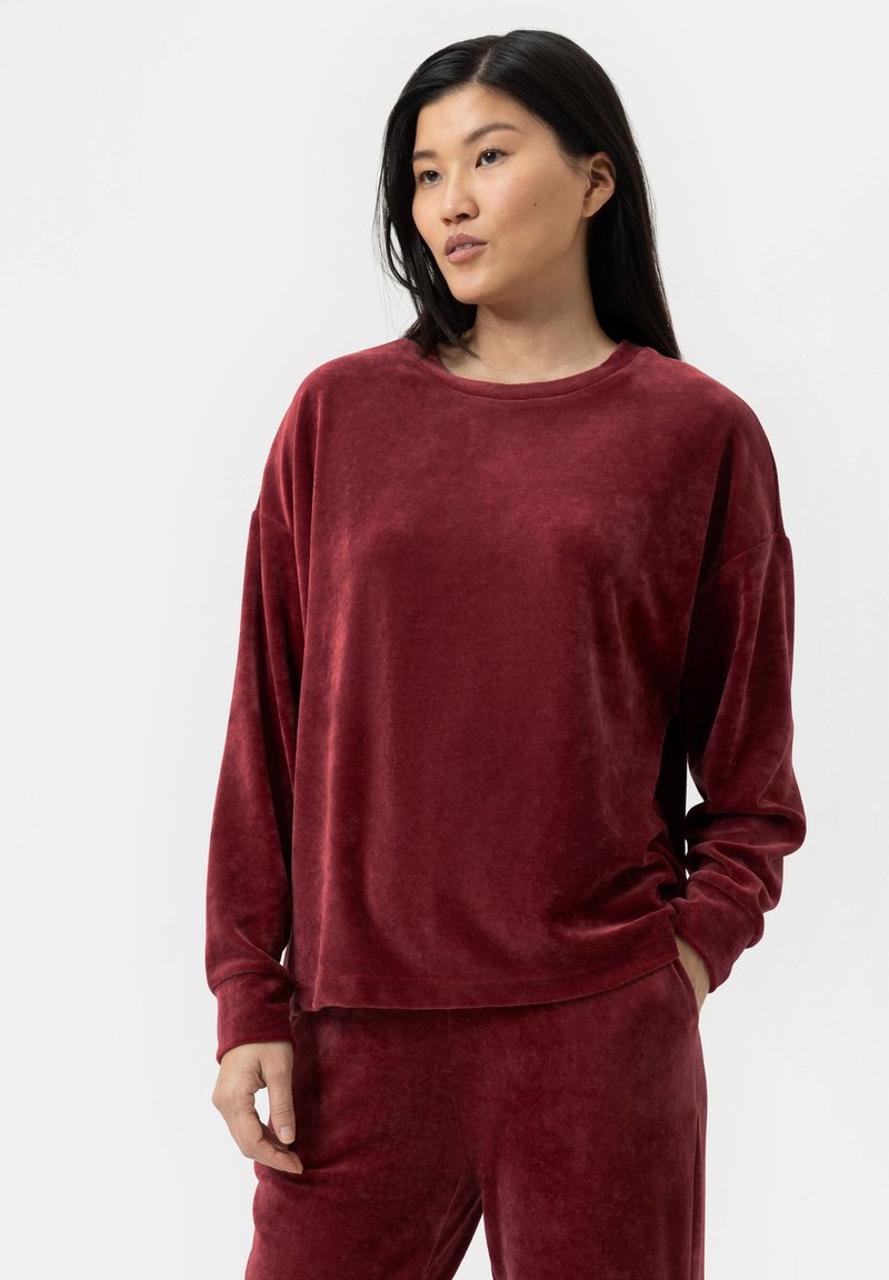 Bordeaux, fluweelachtig langemouwen top met een ronde halslijn en een losse pasvorm, gecombineerd met bijpassende broek, met een zachte textuur en subtiele glans.