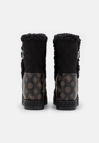 Sorte quiltede støvler med tekstureret imiteret pelskant og mønstret læderdetalje med geometriske designs. Robust sort ydersål med flette detaljer.