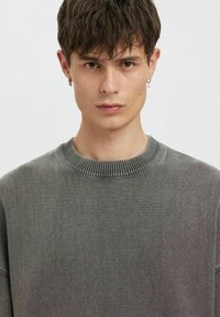 Grau strukturierter Pullover mit einem gerippten Halsbund, schlichtem Design und entspannter Passform, mit dezenten Farbnuancen im gesamten Stoff.