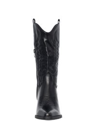 Bota vaquera de cuero negro con punta afilada, diseño de costura en zigzag, lengüetas para tirar y una textura suave. Suela plana y sin herrajes visibles.