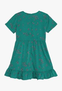 Zelené šaty s krátkými rukávy, květinový vzor v růžové a fialové barvě, volánový lem a zapínání na zip na zádech. Měkká látka s flekatou texturou.