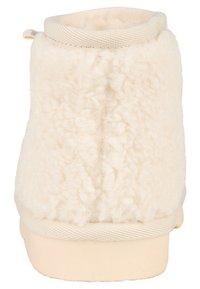 Cremefarbene Knöchelstiefel aus einem weichen, strukturierten, flauschigen Material, mit elastischem Kragen und einer glatten Gummisohle. Einfaches Design ohne sichtbare Hardware.