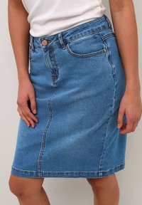 Denim krilo v svetlo modri barvi s ravno zasnovo, spredaj z gumbom, petimi žepi in kontrastnim šivom ob šivih.