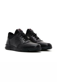Zapatillas de cuero negro con una parte superior texturizada, cierre de cordones y acentos de hardware prominentes. Presenta una suela acolchada y detalles de malla.