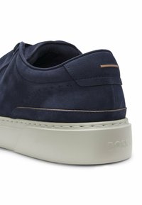 Navy blue suede sneaker heel with white sole, brown accent, and embossed "BOSS" branding on the back of the sole.