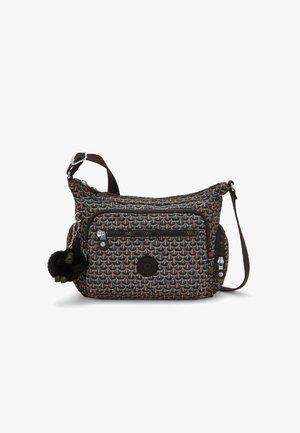 Tasche mit mehrfarbigem, geometrischem Stoffmuster, schwarzem Reißverschluss, strukturierten Akzenten und einem fluffigen schwarzen Pom-Pom-Schlüsselanhänger.
