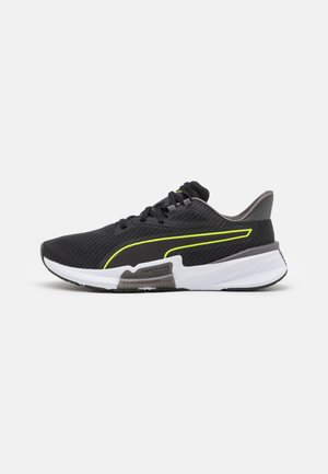Scarpe sportive nere con una parte superiore in mesh testurizzato, dettagli in giallo neon e una suola intermedia bianca. Presentano un tallone imbottito e una suola in gomma durevole.