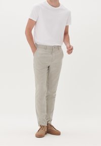 Light grey plaid trousers made of woven fabric, featuring a straight fit and a button closure. Paired with a plain white t-shirt and brown shoes.