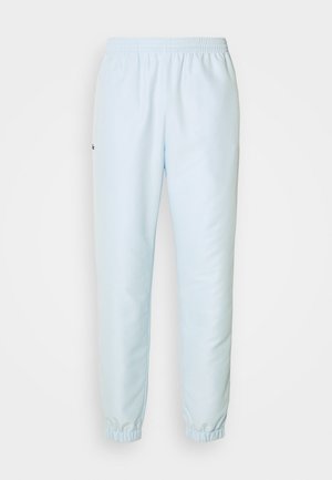 Pantalones sudorosos de color azul claro con cintura elástica y puños en los tobillos, confeccionados en tela suave y con un pequeño logo en el lado izquierdo.