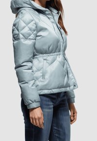 Chaqueta de plumas acolchada en azul claro, con capucha, cintura elástica, bolsillos laterales y una textura suave y brillante.