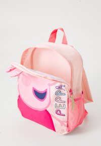 Mochila rosa com o rosto de um personagem de desenho animado de um lado, bolso com zíper e detalhes em malha. Tecido suave com forma estruturada.
