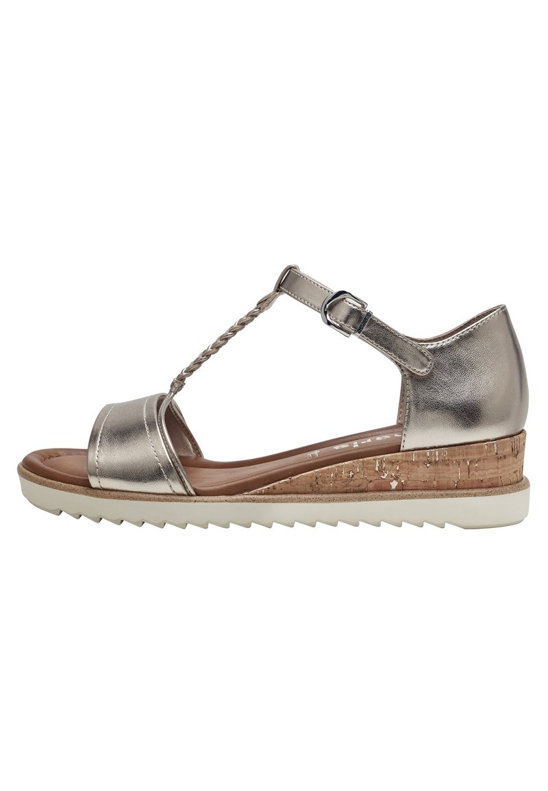 Metalik sivi sandal s T-rem dizajnom, čepovim klinastim potplatom i teksturiranim dnom. Podesivi remen za gležanj i pleteni detalj na remenu.