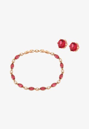 Złota bransoletka i pasujące kolczyki na sztyft z owalnymi i okrągłymi czerwonymi kamieniami szlachetnymi oraz małymi przezroczystymi akcentami.