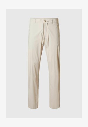 Beezid püksid, mis on valmistatud kerge kangaga, millel on elastne vöökoht ja nööri tõmbamine, sirged sääred ja sile tekstuur.