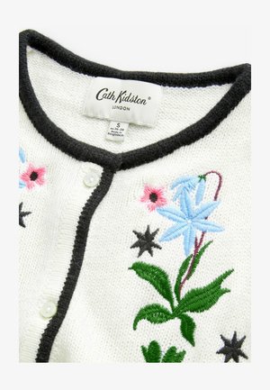Weißer Strickcardigan mit schwarzem Abschluss, der farbenfrohe Blumenstickerei in Blau, Pink, Grün und Schwarz aufweist. Vorderer Knopfverschluss.