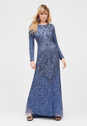 Vestido largo de manga larga con lentejuelas azules, patrones de cuentas intrincados, silueta ajustada y capa transparente. Detallado con un escote redondo.