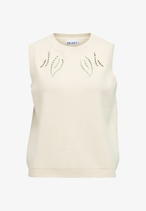 Haut sans manches en maille crème avec un col rond et des motifs découpés en forme de feuille sur la poitrine, bordures côtelées au niveau du col et de l'ourlet.