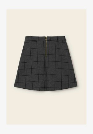 Mörkgrå A-linjeformad kjol med svart rutmönster och en guldfärgad dragkedja mitt fram på beige bakgrund.