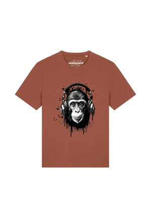 T-shirt couleur rouille avec un graphisme d'un gorille portant de grands écouteurs noirs, entouré d'effets d'éclaboussures de peinture noire.