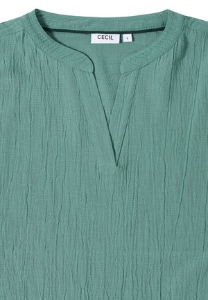 Green textured blouse with a mandarin collar, featuring a front slit and a relaxed fit. Made from a lightweight, crinkled fabric.
