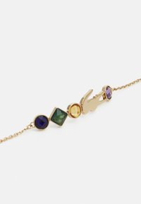 Gouden armband met vier gekleurde edelstenen: ronde paarse, vierkante groene en ronde gele, met een gouden bedel en kreeftsluiting.