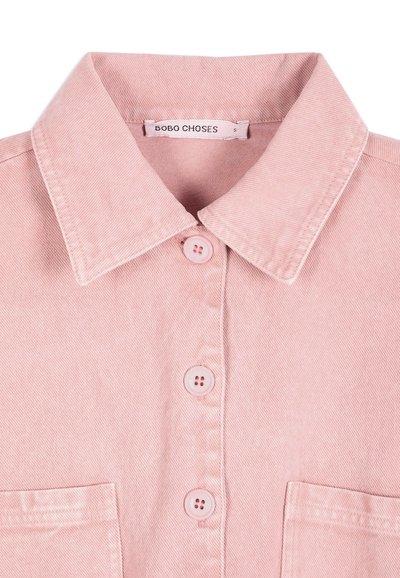 Chemise rose clair à boutons avec col et deux poches avant, affichant l'étiquette de la marque "BOBO CHOSES" et l'étiquette de taille petite.
