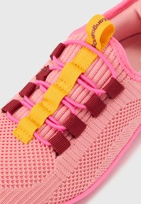 Spordijalatsid roosa kudumisega ülemise osaga, elastsed paelad kollase ja roosa värvusega, tumepunaste detailidega ja tekstuurse tallaga.